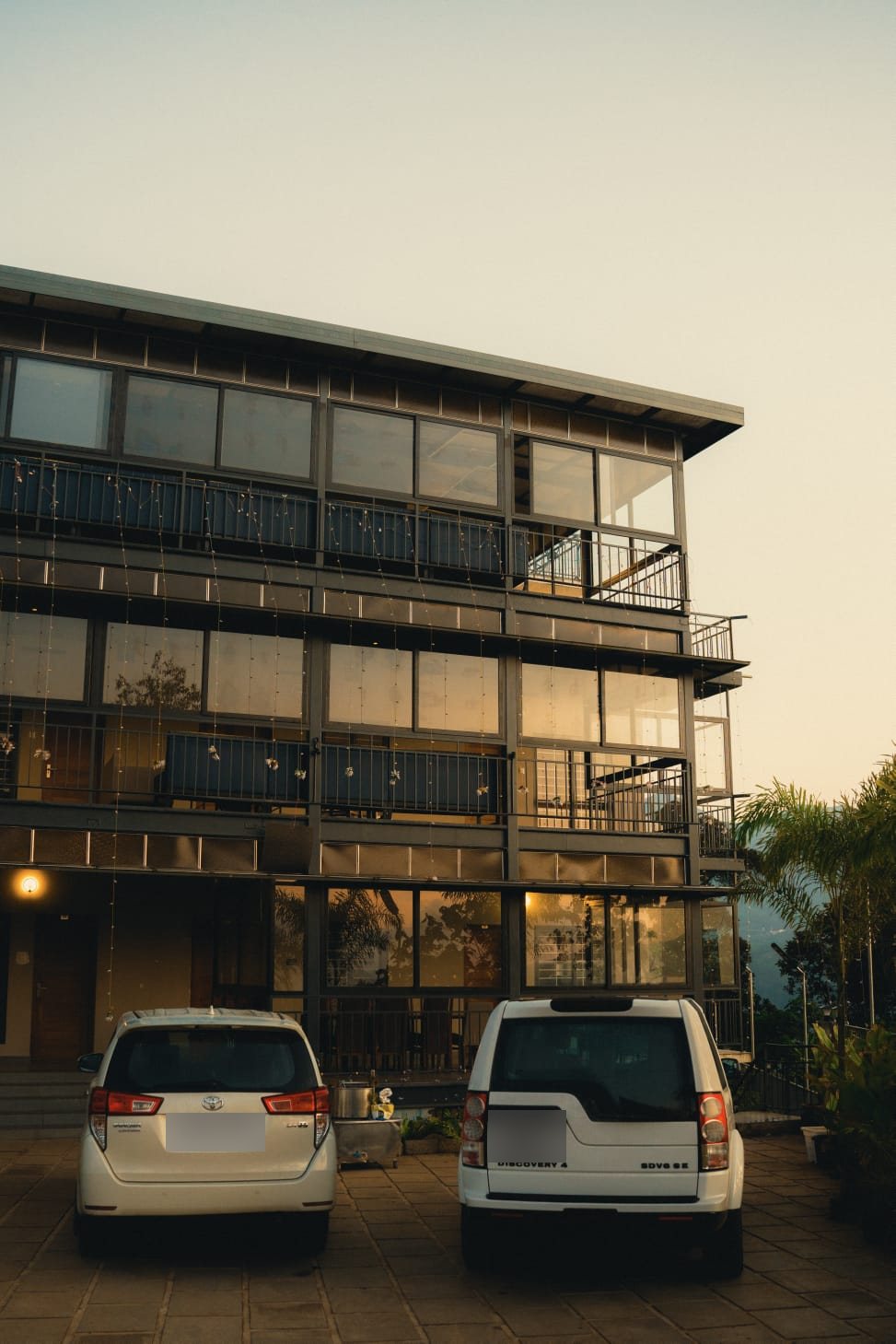 The glass-fronted building at dusk, lit from within
